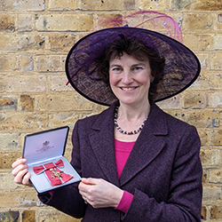 Photograph of Rebeca Fitzgerald holding her OBE medal